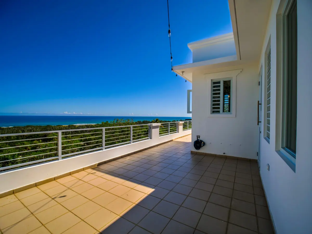 The long terrace with string lights overhead, the ocean beyond the railing